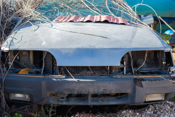 Abandoned old car in a junkyard. Front view.