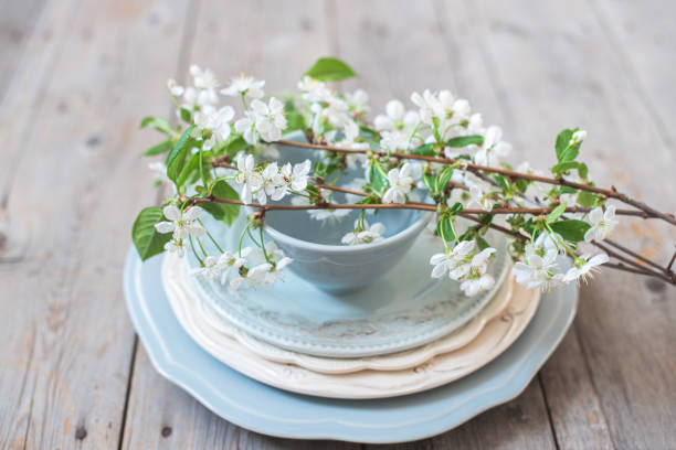 istock Branches of white cherry blossoms on a stack of blue plates 1195262627