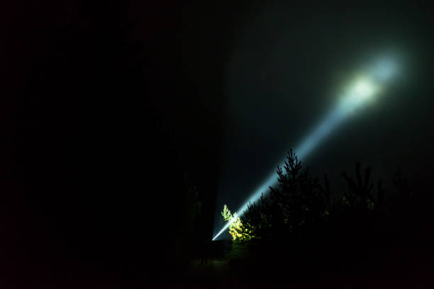 istock Man standing outdoor at dark night shining with flashlight 1195272101
