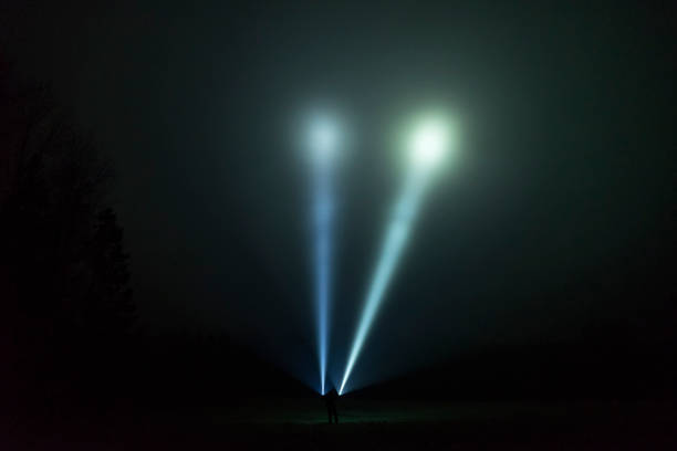 istock Man standing outdoor at dark night shining with flashlight 1195272165