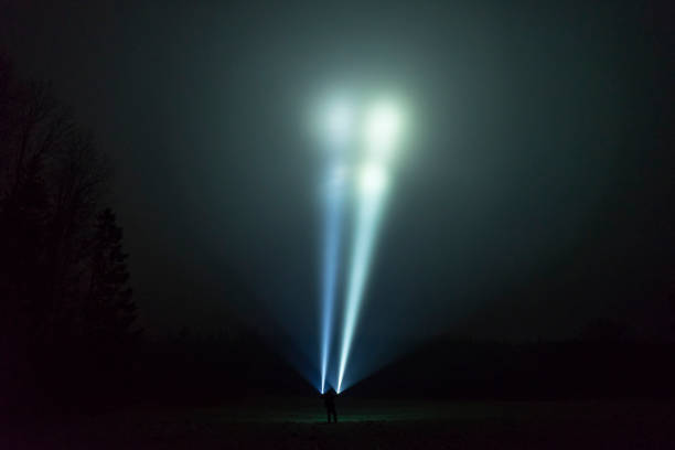 istock Man standing outdoor at dark night shining with flashlight 1195272818