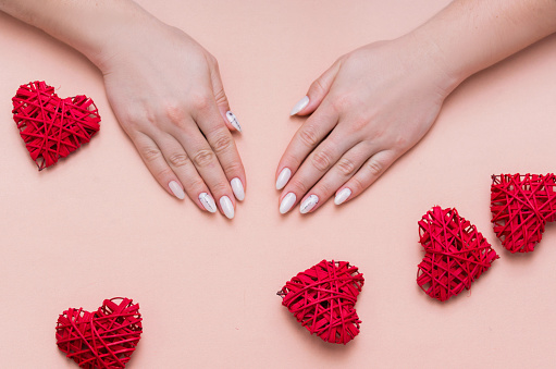 Beautiful stylish female manicure on a pink background with valentinos decor