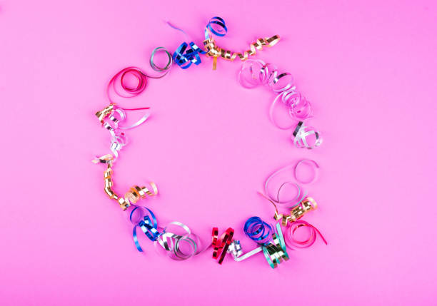 istock Shape a circle on a bright pink background of multi-colored serpatins. Place for the inscription 1195274066