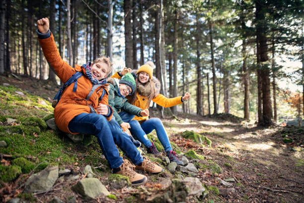 istock Three kids enjoying hiking in forest 1195274102