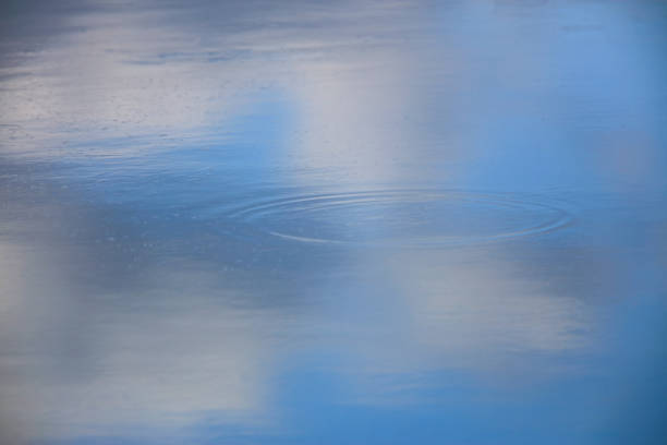 Pictured blue sky reflected on the surface of the water with the ripple.