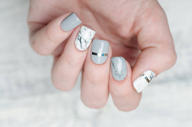 white grey marble manicure with silver stripe on grey background