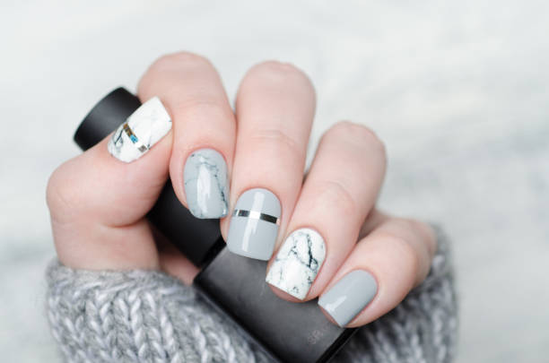 istock white grey marble manicure with silver stripe on grey background 1195283210