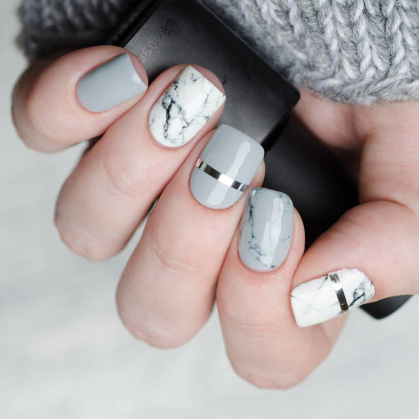 istock white grey marble manicure with silver stripe on grey background 1195283213