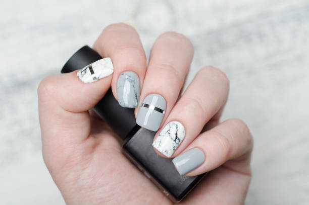 istock white grey marble manicure with silver stripe on grey background 1195283223