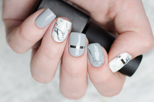 istock white grey marble manicure with silver stripe on grey background 1195283236