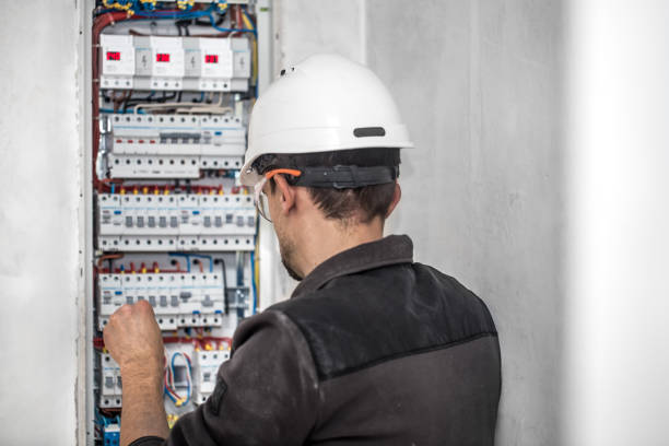 istock Man, an electrical technician working in a switchboard with fuses. Installation and connection of electrical equipment. 1195293971