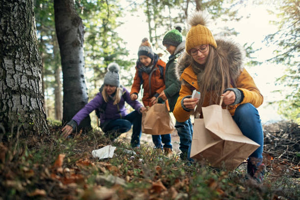 hikers family cleaning up the forest - sustainable resources environment education cleaning imagens e fotografias de stock