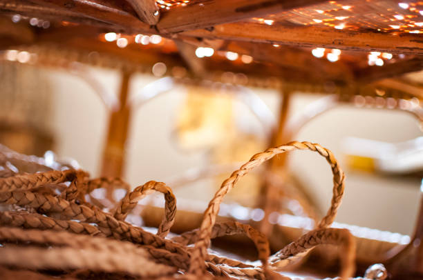 Handwoven twine curled under handwoven bamboo table with dappled sunlight shining through.