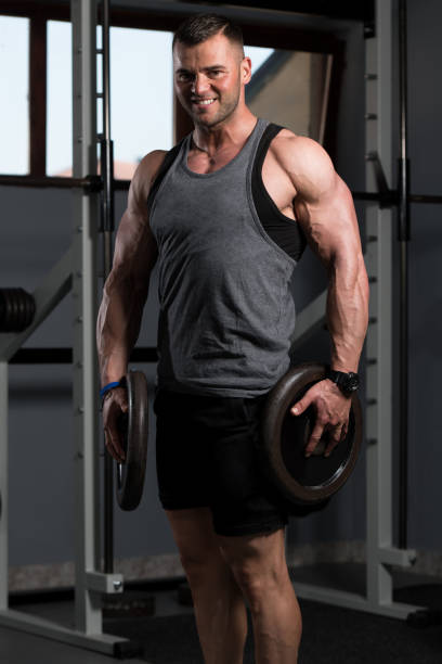 istock Fit Man Holding Weights In Hand 1195310095
