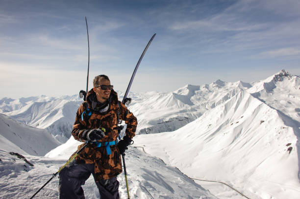 istock Man poses with ski and other equipment 1195311699