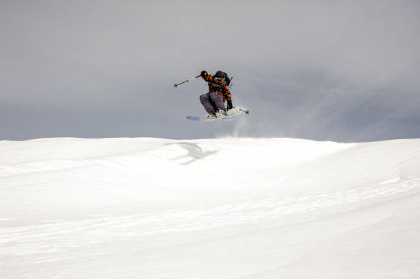 istock Skier jumps in the air while gliding down 1195311760