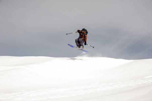 istock Skier jumps in the air while sliding down 1195311767