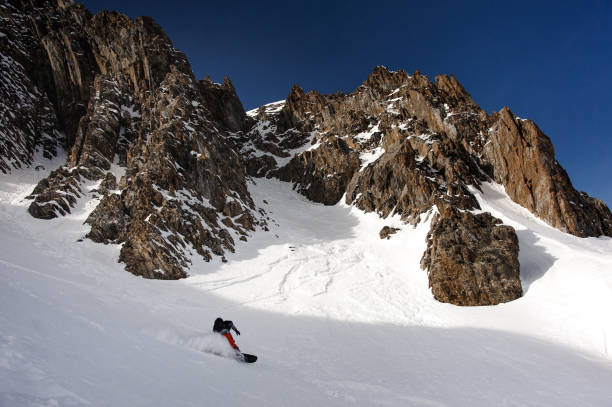 istock View at snowboarder sliding down the mountain side 1195312382