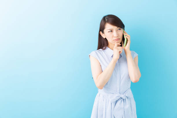 istock asian woman who talks on the telephone,think 1195317383
