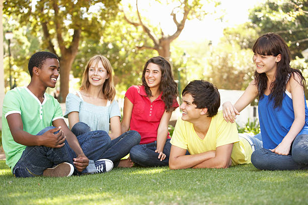 adolescenti chiacchierando insieme nel parco - solo adolescenti foto e immagini stock