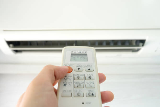 istock Man's hand using remote control open The air conditioner is cooled to 25 degrees Celsius in his bedroom. Health concepts and energy savings 1195336843