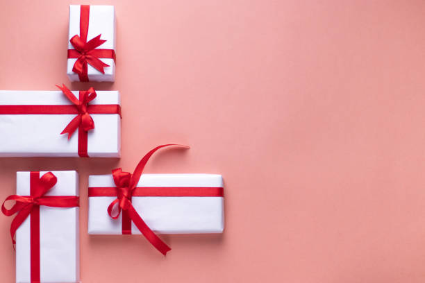 istock White gift box with red ribbon, light coloured background flat lay for stock image 1195342042