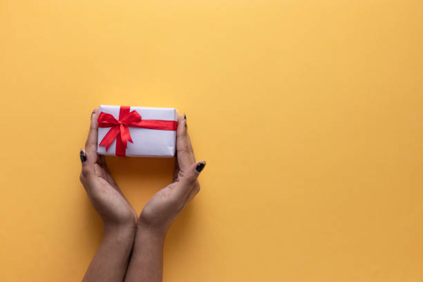 istock White gift box with red ribbon, light coloured background flat lay for stock image 1195343106