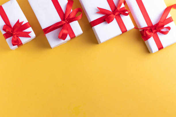 istock White gift box with red ribbon, light coloured background flat lay for stock image 1195343107