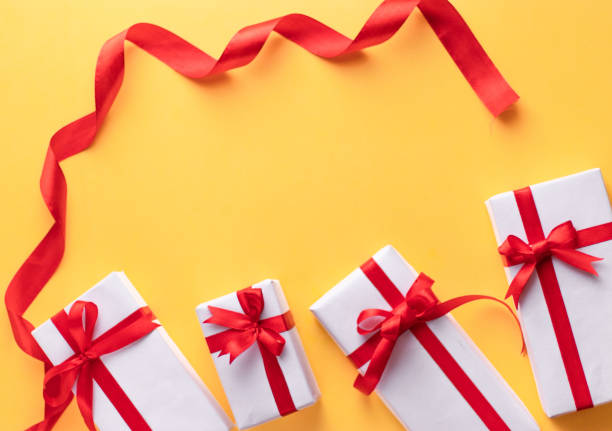 istock White gift box with red ribbon, light coloured background flat lay for stock image 1195343611