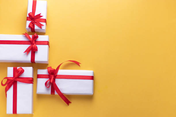 istock White gift box with red ribbon, light coloured background flat lay for stock image 1195343616