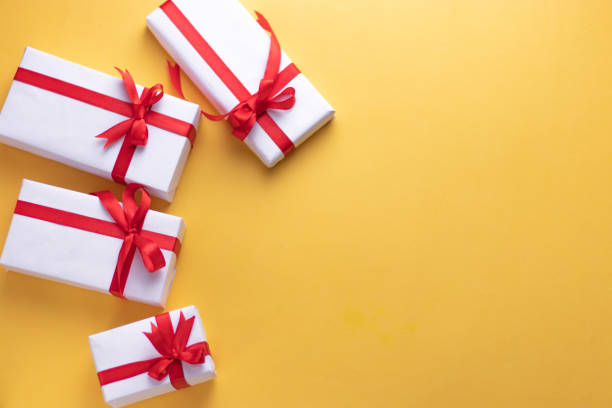 istock White gift box with red ribbon, light coloured background flat lay for stock image 1195343625