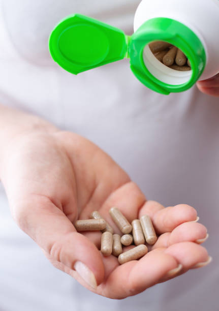 istock woman hand with vitamins and medication 1195355362