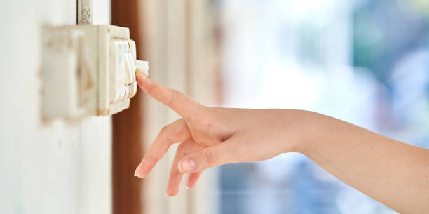 istock Female hand, to turn off the light, switch, side view 1195355560