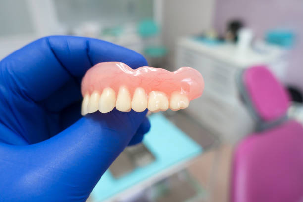 istock removable denture in the hands of a doctor 1195357198