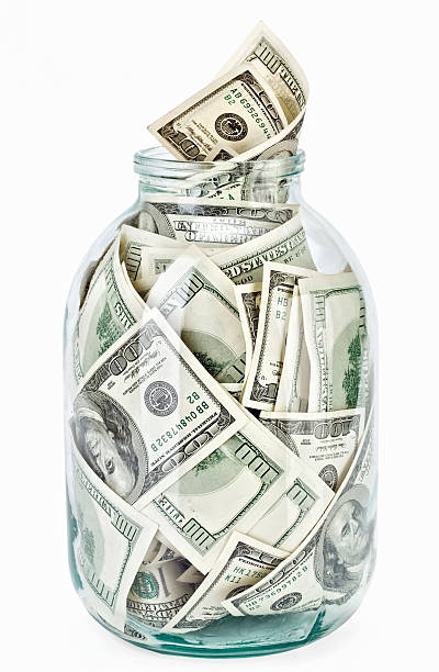 istock Many 100 US dollars bank notes in a glass jar 119535947