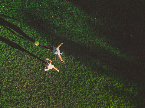drone view on man playing soccer with teengage girl