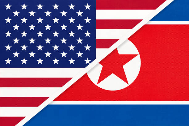 istock USA vs North Korea national flag from textile. Relationship between two american and asian countries. 1195365611