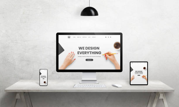 istock We design everything agency resonsive web page on computer, tablet and phone display. Modern devices with thin edges. Modern office, studio desk 1195366416