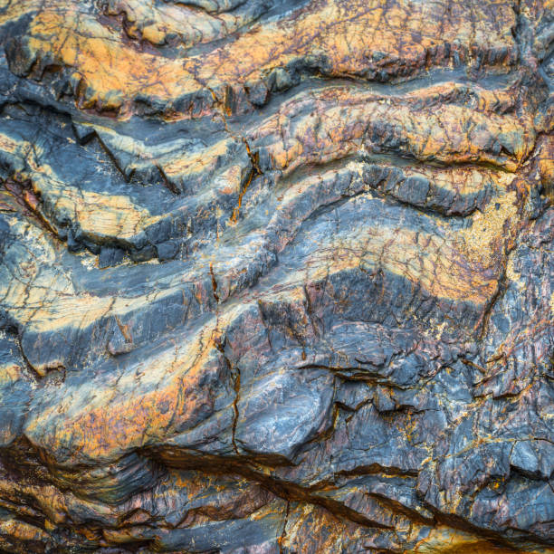 istock Golden strips of pyrite on a blue slate rock 1195370149