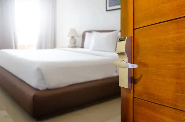 Hotel room , Condominium or apartment doorway with open door in front of blur bedroom background, Copy space image or text