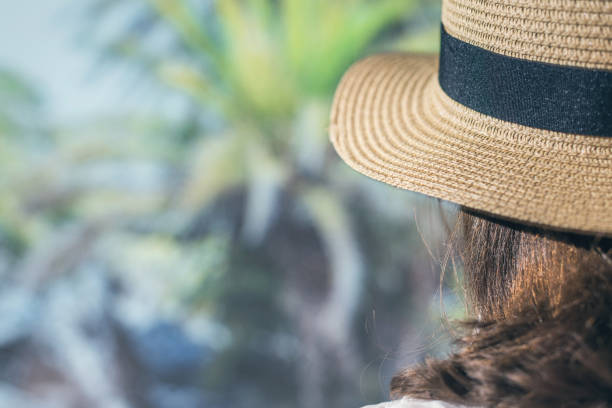 istock Woman in a straw hat in a palm tree grove 1195375634