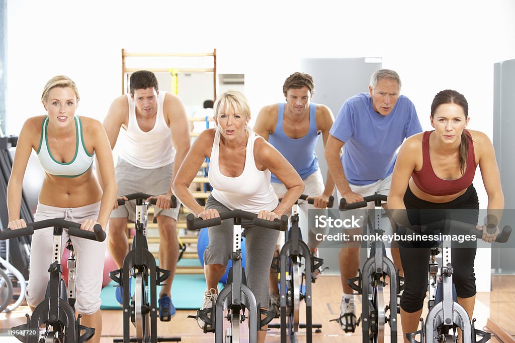 Grupo de pessoas na aula de Spinning na academia de ginástica - Foto de stock de 20 Anos royalty-free