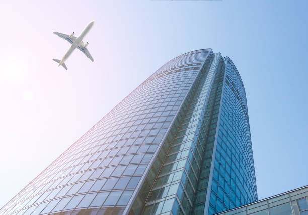istock White passenger aircraft flies over a skyscraper 1195377855