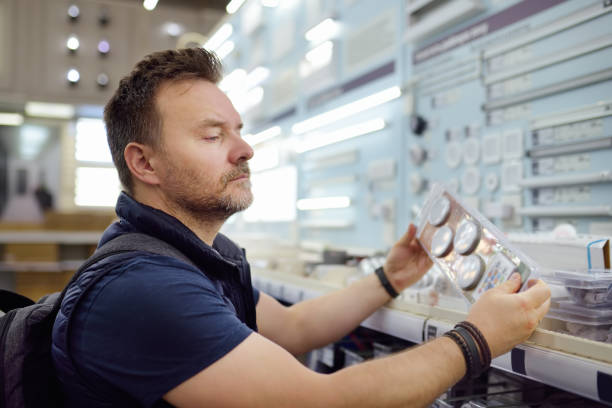istock Middle age man choosing electric lamps in a hardware store. 1195378513