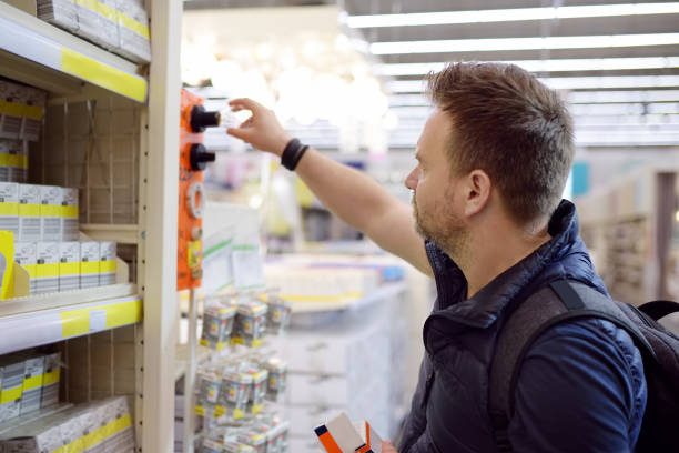 istock Middle age man checks electric lamps in a hardware store. 1195378523