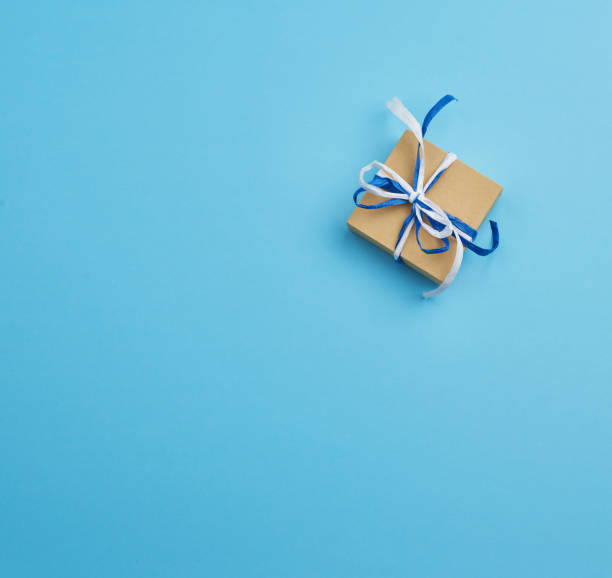 istock brown cardboard gift square box, bows on a blue background 1195378811