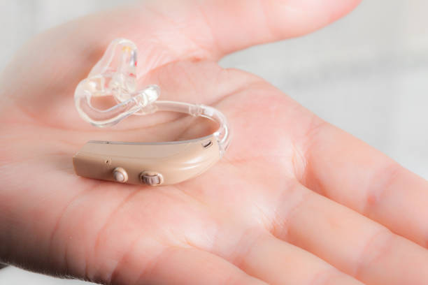 istock senior person holding hearing aid closeup 1195378837
