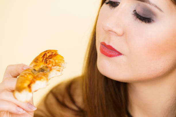istock Woman eating hot pizza slice 1195380469