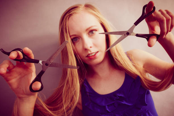 istock Girl with scissors for haircutting 1195380518