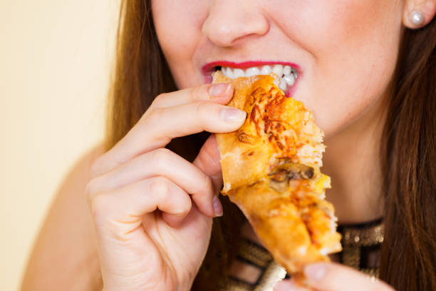 istock Woman eating hot pizza slice 1195380777